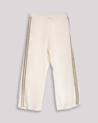 Detalle visual de pantalón bordado blanco zanzibar