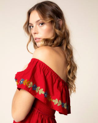Detalle visual de vestido estampado rojo escote bardot creta
